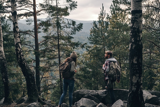 Au milieu de nulle part. Jeune couple debout et regardant loin lors d'une randonnée ensemble dans les bois