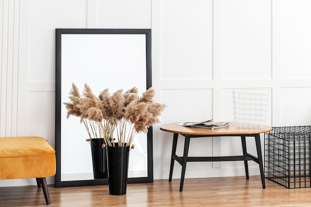 Au sol il y a une banquette orange, un grand miroir et une table en bois