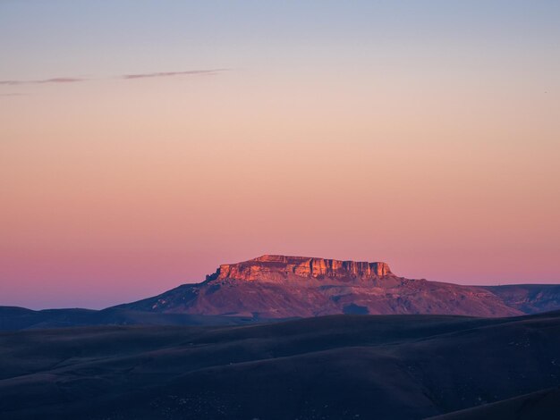 Aube magenta magique sur le plateau de Bermamyt Le paysage de l'aube atmosphérique avec le magnifique plateau de Bermamyt est au loin