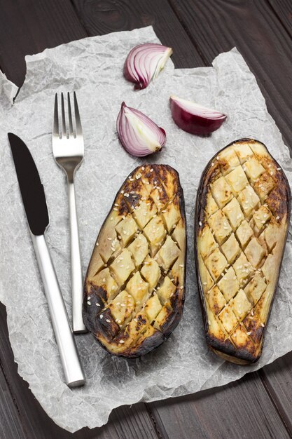 Photo aubergine au four avec couteau à oignons et fourchette sur papier