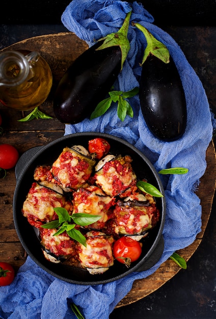 Aubergine (aubergine) roule avec de la viande à la sauce tomate. Mise à plat. Vue de dessus