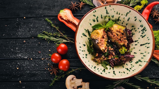 Aubergine farcie de mozzarella de veau et de tomates Vue de dessus Sur un fond en bois noir Espace de copie