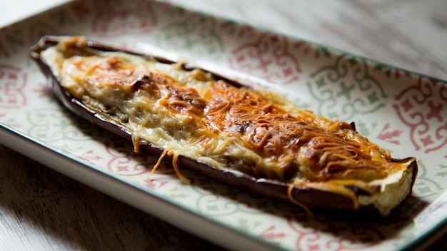 Aubergine farcie de viande hachée et cuite au four avec du fromage.