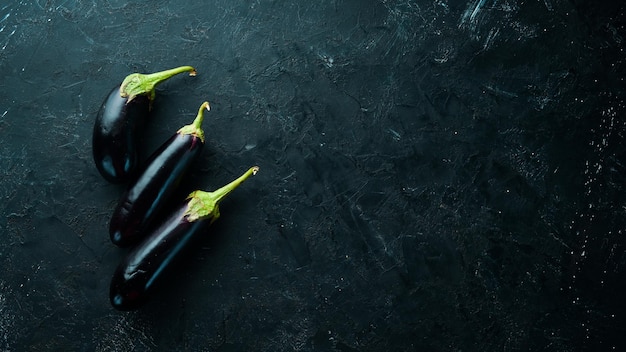 Aubergine fraîche sur fond noir. Des légumes. Vue de dessus. Espace de copie gratuit.