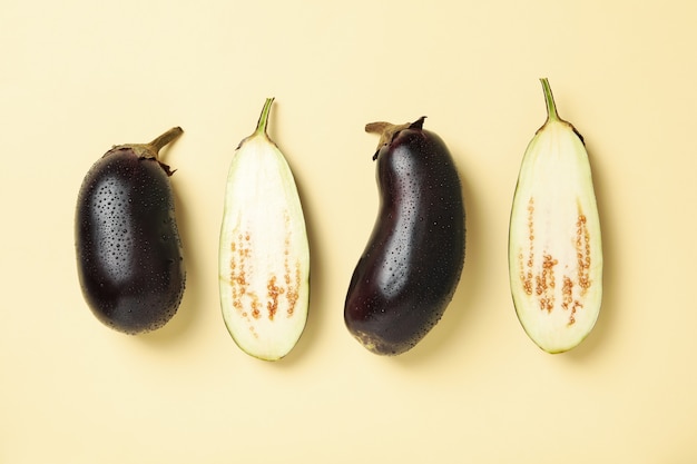 Aubergines crues fraîches avec des gouttes d'eau sur beige