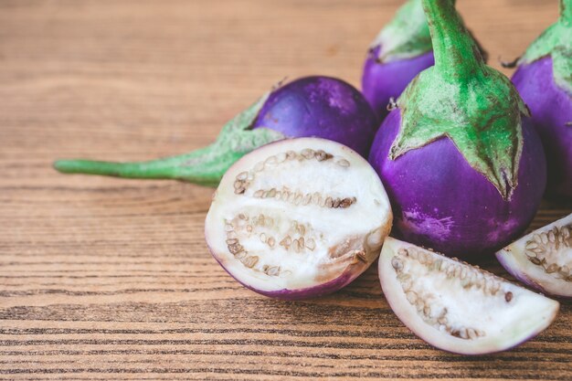 Aubergines pourpres fraîches sur la table en bois.