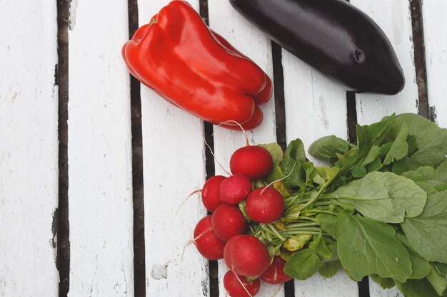 Aubergines radis poivrons rouges sur le dessus d'un tableau blanc