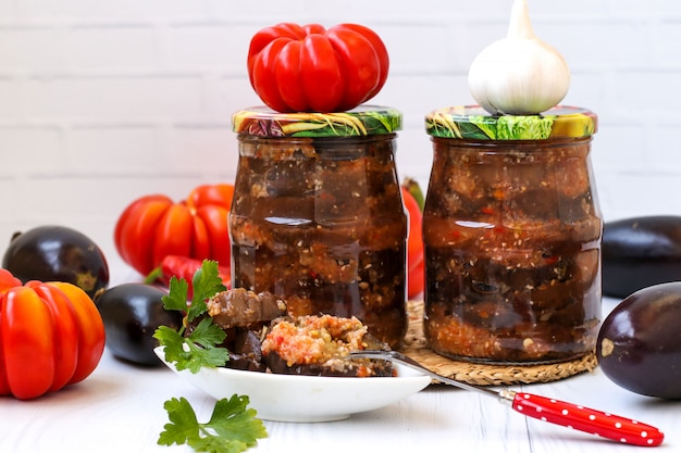 Aubergines En Sauce Aiguë De Poivron, Tomates Et Ail En Bocaux Sur La Table, Récolte Pour L'hiver, Photo Horizontale