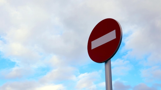 Aucun panneau de signalisation d'entrée, sur un poteau métallique Ne pas entrer contre un ciel bleu avec des nuages