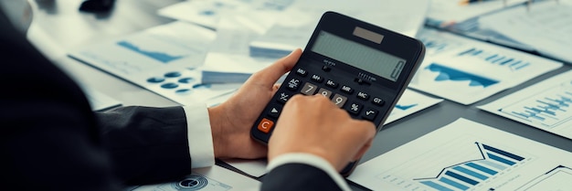 Auditeur d'entreprise calculant le budget avec une calculatrice sur son bureau Comptable professionnel dédié d'une entreprise comptable analysant un document financier pour prévoir les revenus Insight