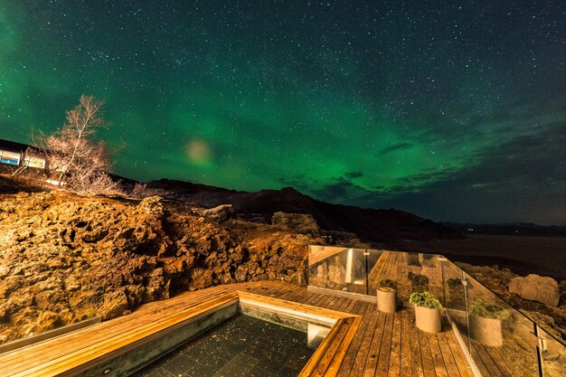 Aurora borealis Lumières du Nord au-dessus de la piscine de sources chaudes dans un hôtel de luxe la nuit