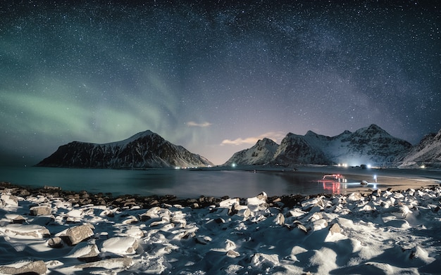 Photo aurora borealis avec voie lactée sur la montagne de neige