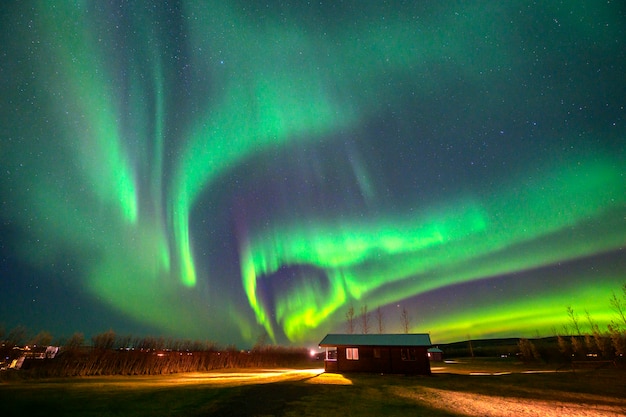 Aurora Dancing au-dessus de la cabane dans une petite ville à la campagne Islande