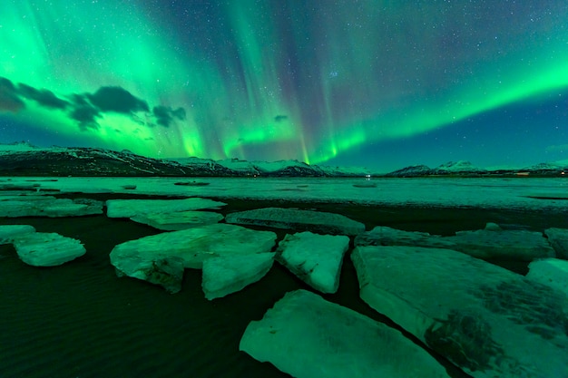 Aurora s'élevant au-dessus d'une belle montagne. En Islande