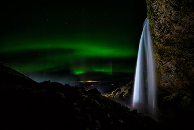 Aurore boréale sur la cascade de Seljalandsfoss en Islande