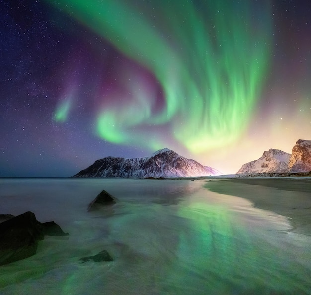 Aurore boréale sur les îles Lofoten Norvège Aurores boréales vertes au-dessus des montagnes et de la plage Ciel nocturne avec aurores polaires Paysage d'hiver nocturne avec aurore Fond naturel en Norvège