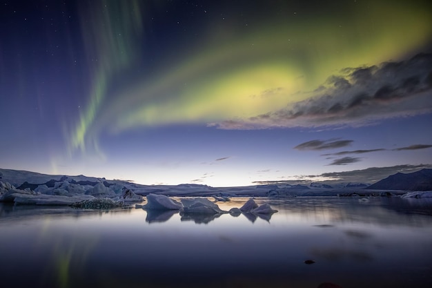 Photo aurores boréales au-dessus d'un lac glaciaire en islande aurore boréale