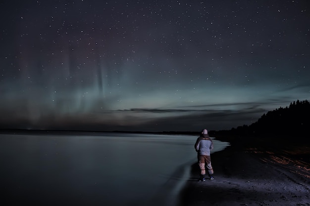 aurores boréales homme solitaire au bord du lac belle nature ciel nocturne paysage