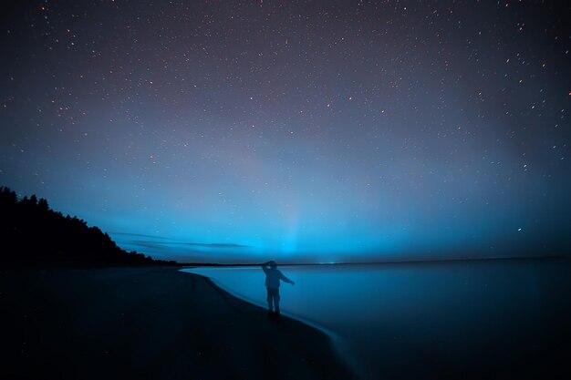 aurores boréales homme solitaire au bord du lac belle nature ciel nocturne paysage