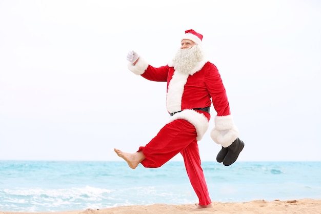 Authentique Père Noël marchant sur la plage