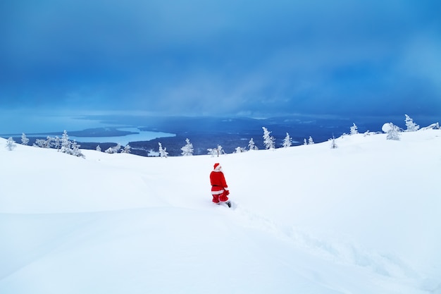 Photo authentique père noël sur une montagne enneigée.