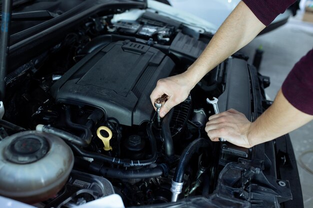 Un automech masculin inspecte le service de voiture de moteur de voitures et la réparation de voiture