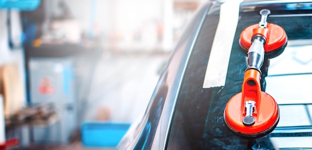 Photo automechanic remplace le pare-brise d'une voiture dans le garage de la station-service automobile