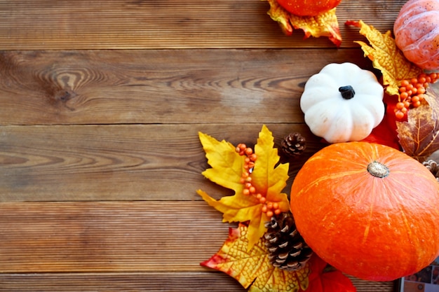 Automne, composition de cadre abstrait d'automne avec des feuilles colorées, des pommes de pin et des citrouilles sur fond en bois, espace de copie.