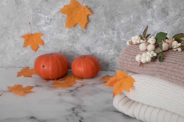 Automne nature morte avec chandails tricotés, feuilles tombées, citrouilles.