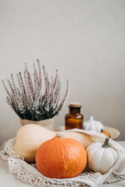 Automne nature morte avec des citrouilles et des feuilles dorées sur une surface en bois Fond de thanksgiving de citrouille d'automne avec sac réutilisable zéro déchet avec des citrouilles sur une table en bois