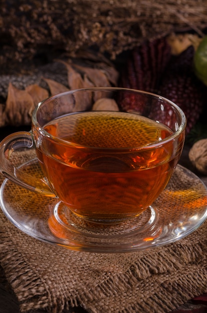 Automne nature morte confortable avec théière en verre et tasse de thé sur une serviette de jute