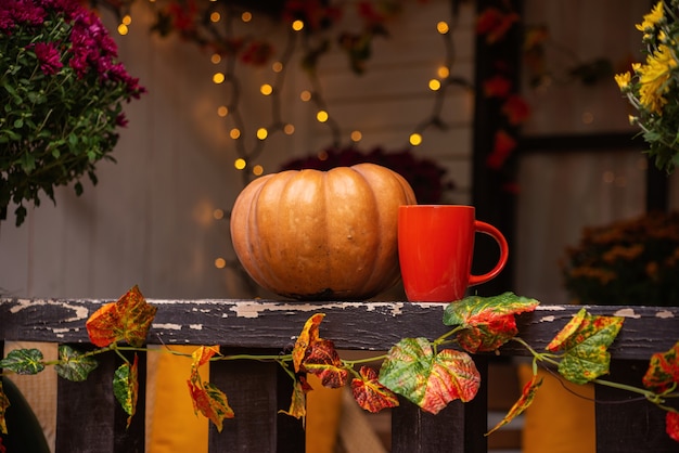 Automne nature morte avec une tasse de thé citrouilles fleurs Thanksgiving ou concept d'halloween