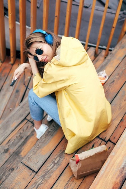 Photo automne portrait d'élégante femme heureuse écoute la musique et prête à l'avoir emporter le déjeuner