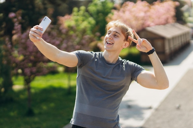 Autoportrait d'un bel homme sportif prenant un selfie sur un téléphone portable à l'extérieur du concept de selfie