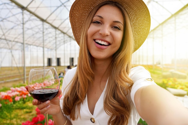 Autoportrait d'une jeune femme attirante à l'extérieur tenant un verre à boire du vin l'activité du week-end