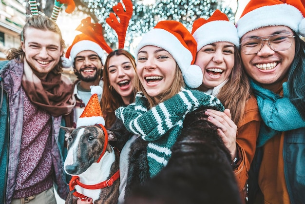 Autoportrait de jeunes métis portant un chapeau de père noël célébrant le jour de Noël à l'extérieur