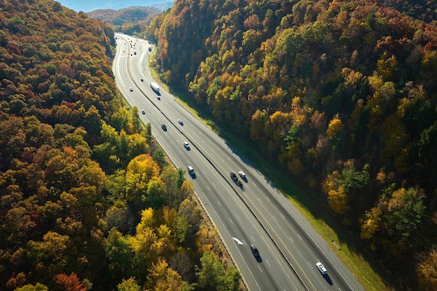 Autoroute I40 menant à Asheville en Caroline du Nord à travers les montagnes des Appalaches avec une forêt d'automne jaune et des camions et des voitures en mouvement rapide Concept de transport interétatique à grande vitesse