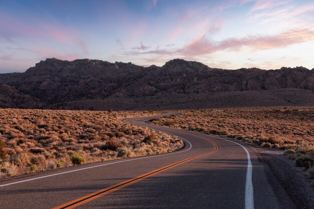 Autoroute panoramique dans le ciel de coucher de soleil de paysage de montagne