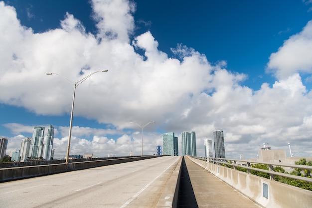 Autoroute ou route publique pour véhicules de transport et gratte-ciel urbains sur fond de ciel bleu nuageux