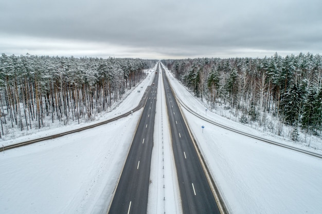 Autoroute traversant la forêt d'hiver.