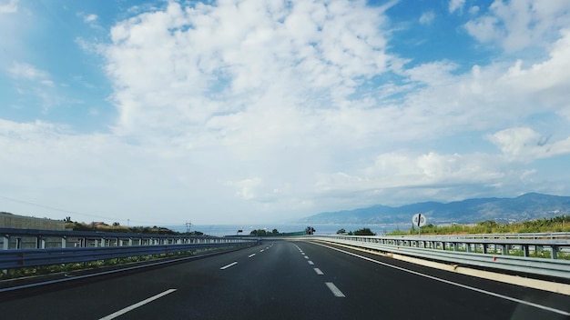 Une autoroute vide contre un ciel nuageux