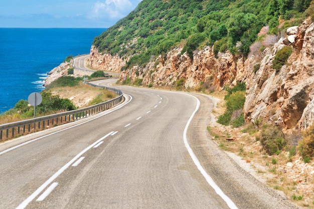 Autoroute vide dans les montagnes sur fond bleu ciel et mer