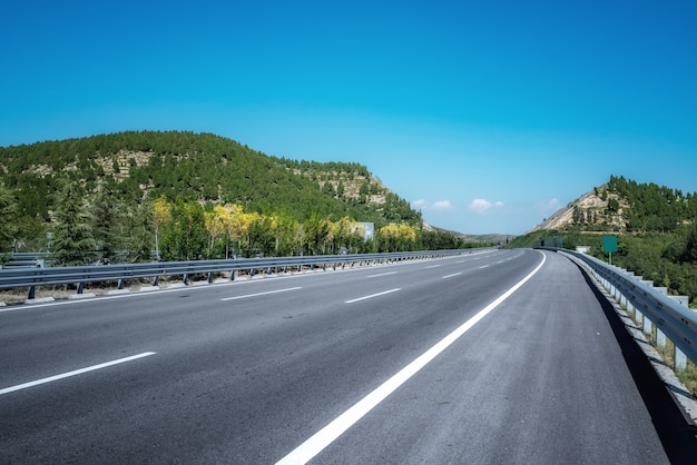 Autoroutes asphaltées et montagnes sous le ciel bleu