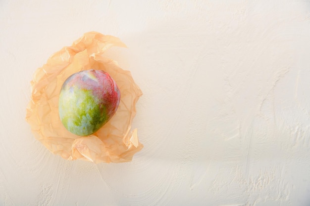 Une autre vue de la nourriture mangue naturelle sur du papier kraft sur un fond texturé blanc Creative collage conceptuel et coloré