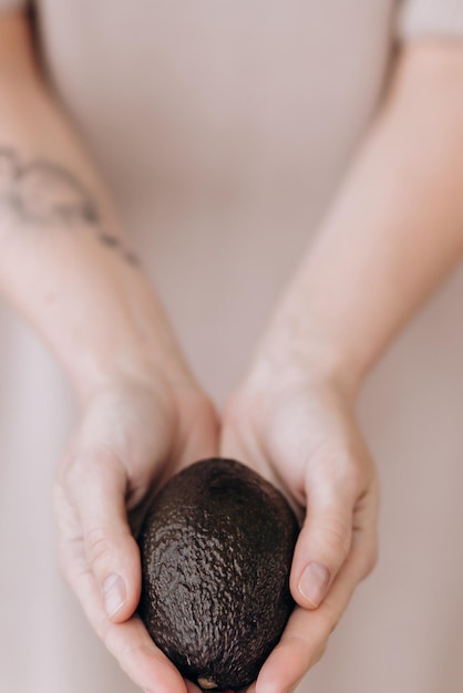 Avacado mûr entre les mains d'une fille