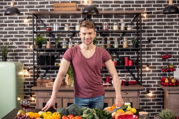 Avant de cuisiner. Aimer un bel homme se sentant excité et joyeux avant de préparer le dîner pour une charmante épouse