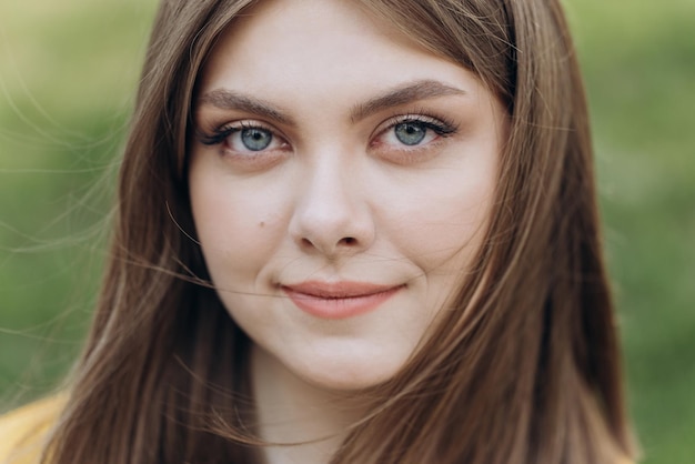 Avant gros plan d'une femme caucasienne beau jeune visage humain à la peau blanche sourire regarder la caméra ouverte et confiante Portrait d'une dame européenne caucasienne