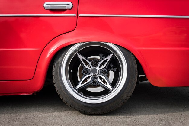 Avant de la voiture pour ajuster la suspension inférieure au sol. Vue latérale sur la nouvelle roue de voiture de luxe sur jante en métal argenté avec pneu noir brillant. Roue de voiture de sport de luxe avec pneu à profil bas. Tuning de voiture,