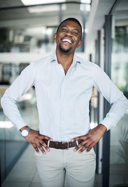 L'avenir que je me suis fixé est un succès Photo d'un beau jeune homme d'affaires debout seul dans son bureau avec ses mains sur ses hanches pendant la journée