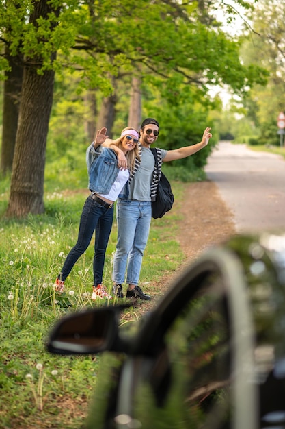 Photo aventure. deux personnes essayant d'arrêter la voiture dans la forêt et semblant joyeuses